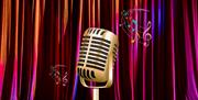 Vintage microphone on stage in front of curtains