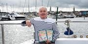 Skipper Brian Meharg poses with his book on Jenny Watts