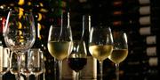 Filled wine glasses and wine bottles