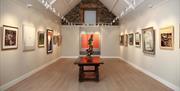 a room in an art gallery with paintings on the wall