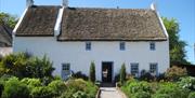 Photo of one of the beautiful thatched houses and lush gardens on site at Ulster Folk Museum