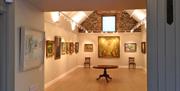 a room in an art gallery with paintings on the wall