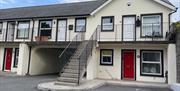 This is the ground floor picture of the apartment which has a red door and window of the livingroom to the front of the apartment living room and kitc