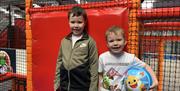 Two Boys holding footballs in the Airtastic Soft Play Frame