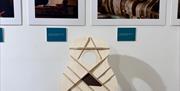 Front section of a Guitar with photographs behind it on the wall