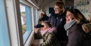 Family taking part in a guided birdwatching session in the Brent Discovery Hide.