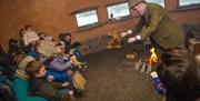 Group of families with performer inside the crannog hut