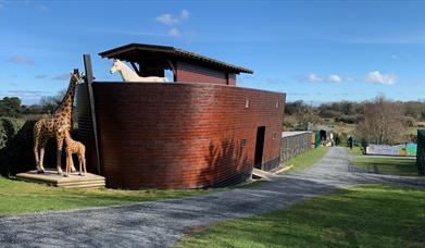 Image of the Ark Open Farm's small replica of Noah's Ark with animal statues including giraffe