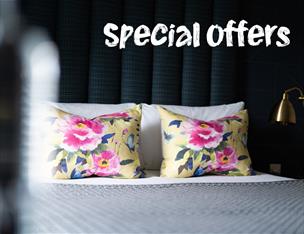 An image of a made up hotel bed with text saying Special Offers