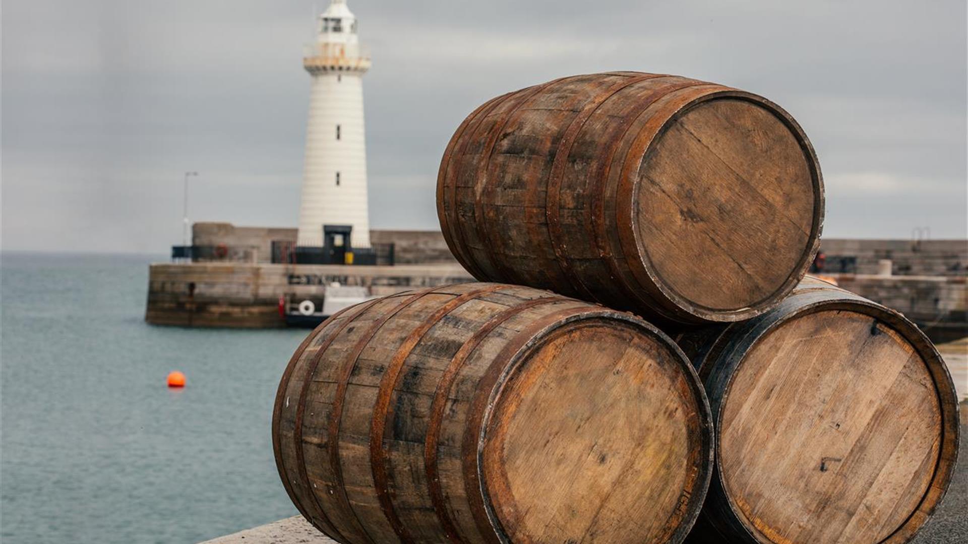 Three barrels stacked in a triangle on Donaghadee Pier with the lighthouse in the background