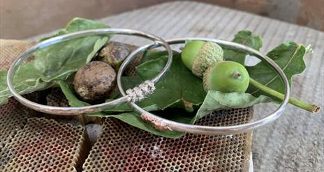 a photograph of 2 silver bangles with leaves and acorns