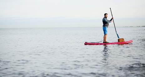A photo of a man on a paddleboard