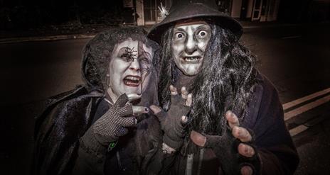 a photo of a man and woman dressed up as witches
