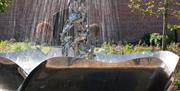 Close up of water fountain in centre of walled garden