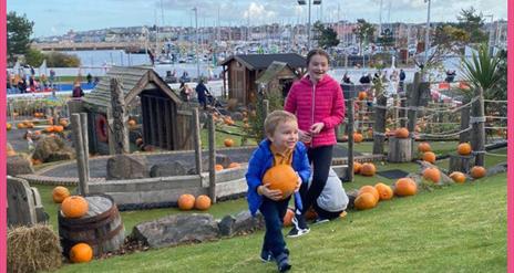 Kids enjoying picking pumpkins