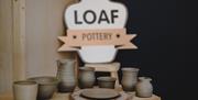 Loaf pottery logo sign with some pottery pieces