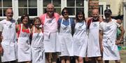 A group adorned in Tracey's aprons posing for the photo