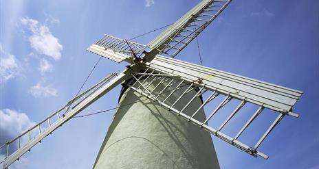 a photograph looking up at a windmill with a blue sky in the background
