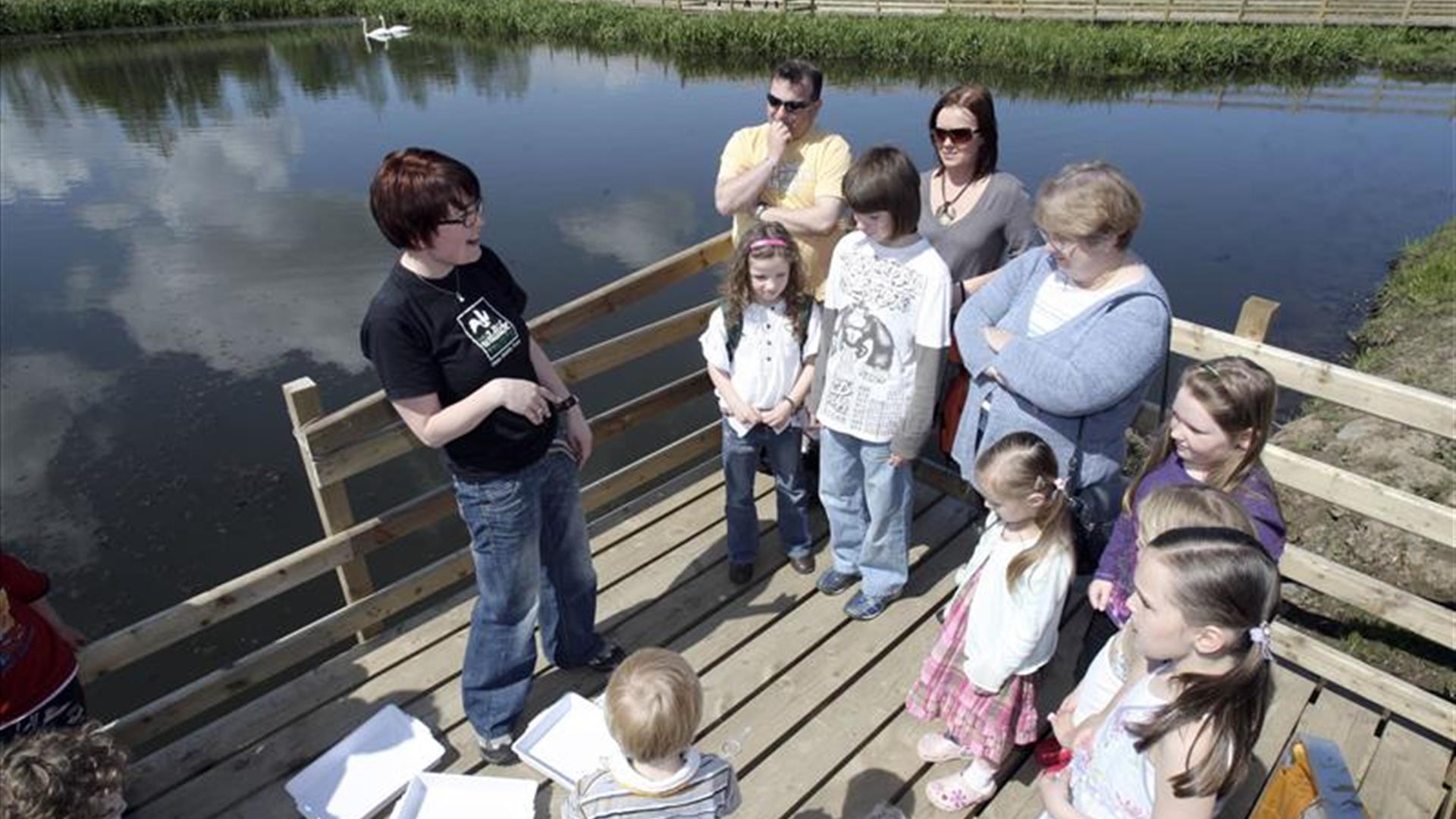 a photograph of a group of people standing next to a lake
