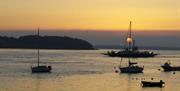 Image of Strangford Ferry and yachts moored in the waters at sunset