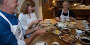 A group enjoying freshly homemade treats around the dining table in Tracey's Kitchen