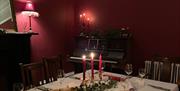 Dining table, set with lit candles and seasonal decoration