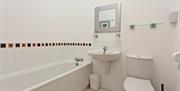 Photo of white bathroom with bath
