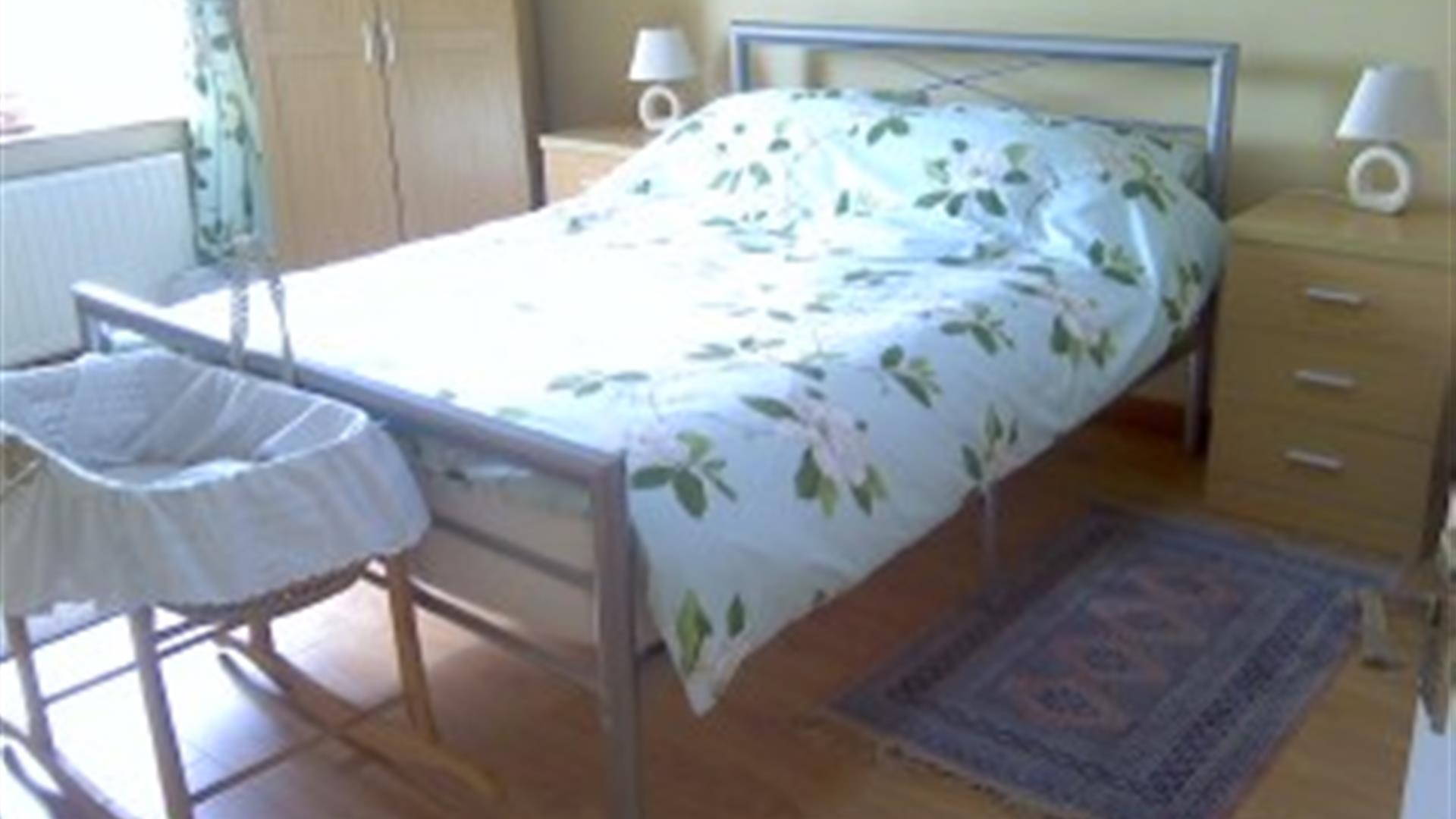 Double bed with bedside tables and baby moses basket