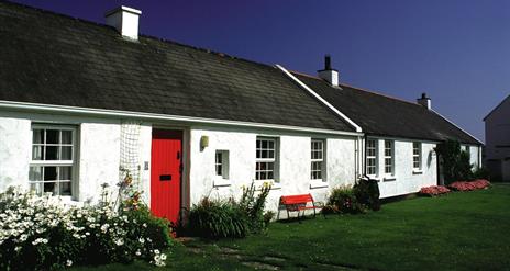 a photograph of the exterior of some terraced white cottages