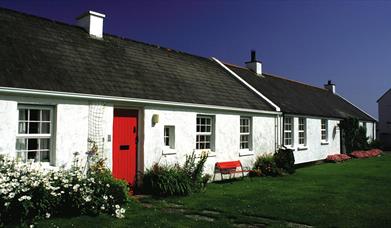 a photograph of the exterior of some terraced white cottages