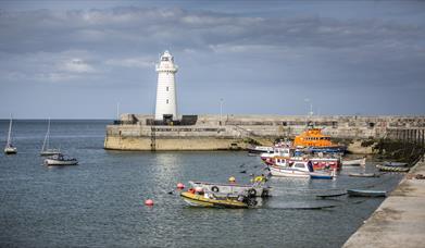 Image of Donaghadee lighthouse and boats tied in the harbour