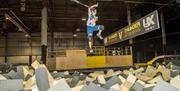 Image of someone practicing scooter tricks over a foam pit