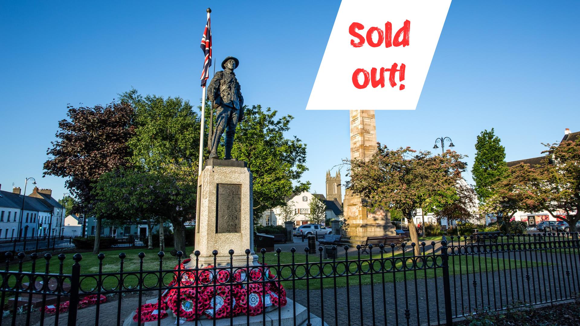 Photo of the Rollo Gillespie Monument standing tall in the centre of Comber Square with text Sold Out