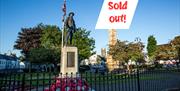 Photo of the Rollo Gillespie Monument standing tall in the centre of Comber Square with text Sold Out