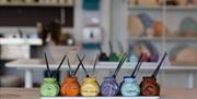 Photo of paint pots of all colours lined up ready for use