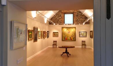 a room in an art gallery with paintings on the wall