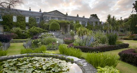 Photo of the formal gardens in colourful bloom at Mount Stewart with the Estate House in the background