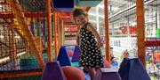Little Girl Smiling For the Camera in the Airtastic Soft Play Frame