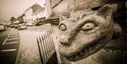 Close up sepia coloured photo of the gargoyle features on Market Cross