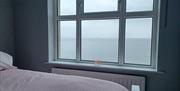 Front bedroom with seaview. Pink duvet cover with grey/blue walls