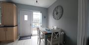 Kitchen table for 4 people. Massive clock on wall. Back door out to small patio with vintage bistro table and chairs