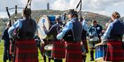 A Pipe Band performs in Ards Airfield with Scrabo Tower in the background