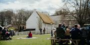 Visitors enjoying picnics in the grounds of the Folk Museum