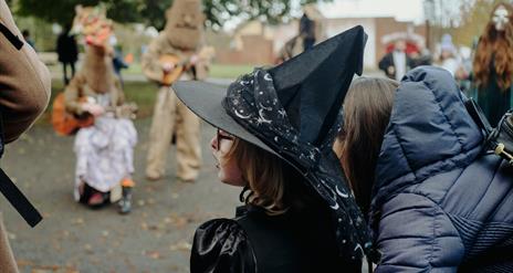 a little girl wearing a black witches hat
