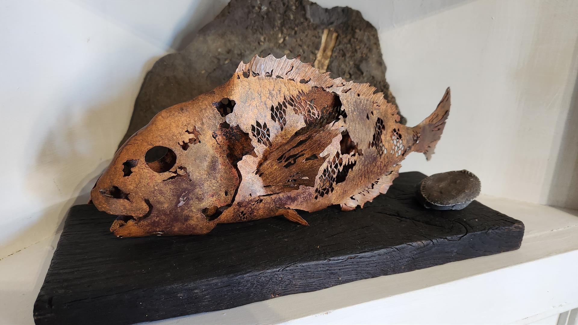 Copper fish on black wood, created by Lake & Oak Coppersmithing artists