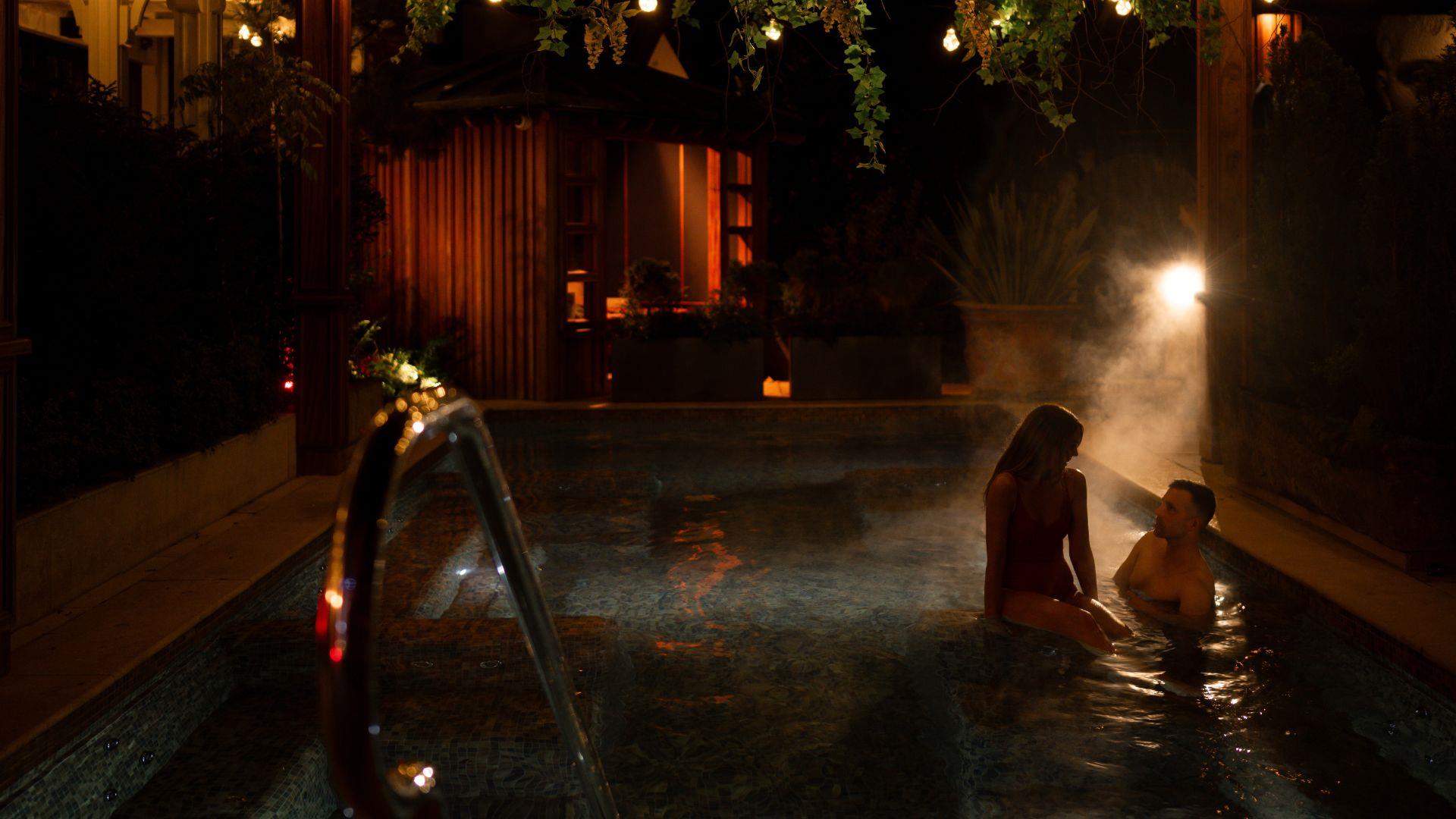 female and male in an outdoor heated pool in The Treetop Spa female and male in an outdoor heated pool in The Treetop Spa